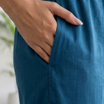 Close-up view highlighting the convenient functional side utility pocket tailored into the matching royal blue crepe straight-fit trousers of a hand embroidered kurta set, showing a hand resting inside.