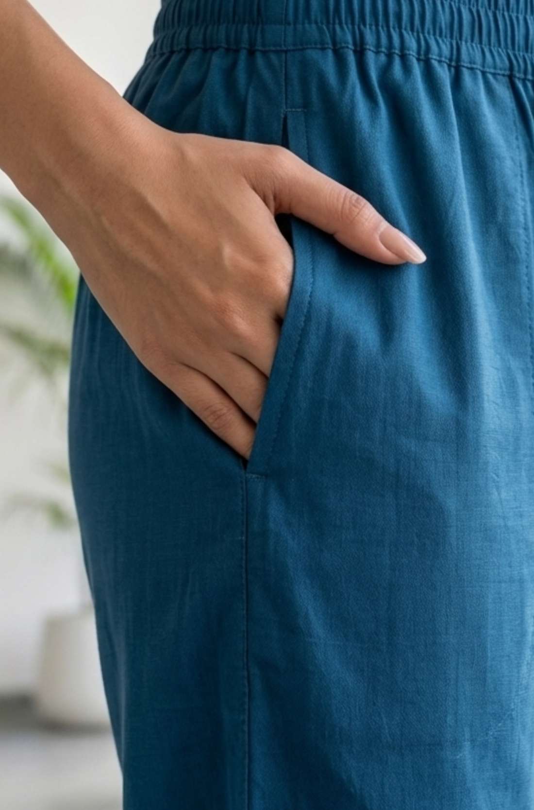 Close-up view highlighting the convenient functional side utility pocket tailored into the matching royal blue crepe straight-fit trousers of a hand embroidered kurta set, showing a hand resting inside.
