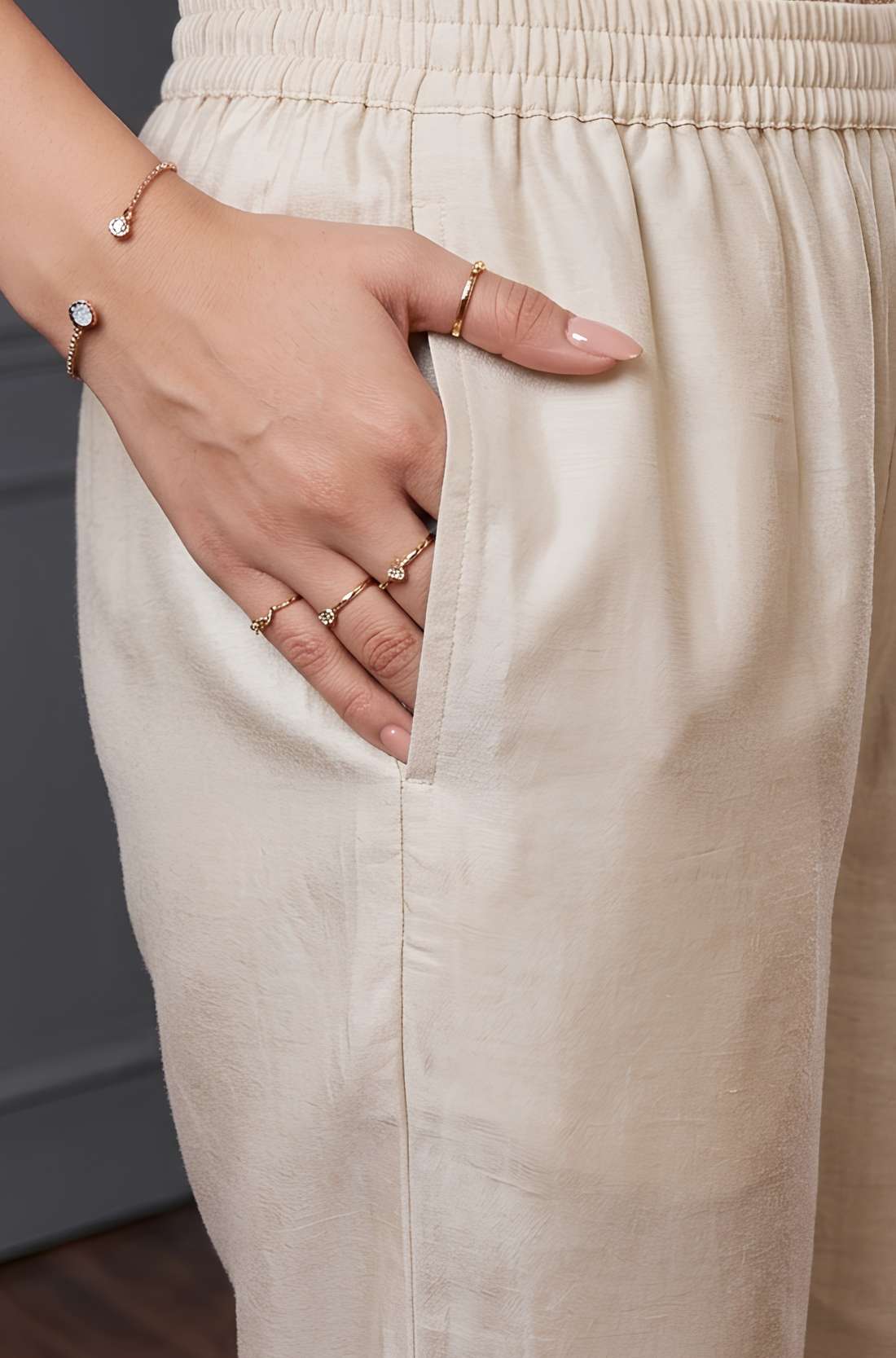 Close up view highlighting the functional side utility pocket tailored into the matching straight trousers of a premium scalloped embroidered silk 3 piece kurta set, with a hand resting inside the pocket.