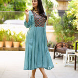 Model wearing sea green art silk flared kurti with aari embroidered yoke and gathered waist