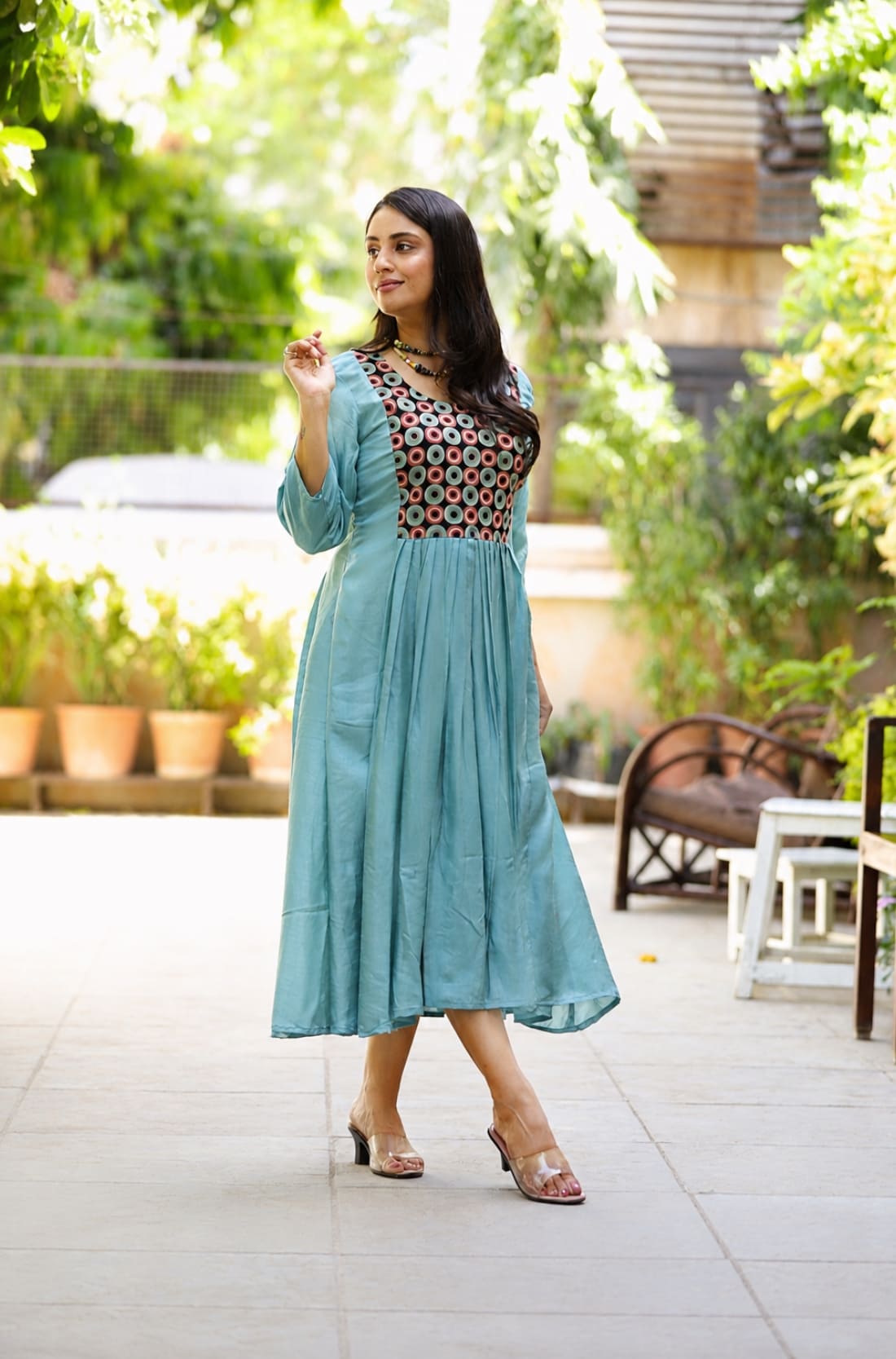 Model wearing sea green art silk flared kurti with aari embroidered yoke and gathered waist