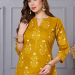 Close up view of the V neckline design showcasing white lace inserts and contrasting border details on the ochre yellow floral printed cotton kurta