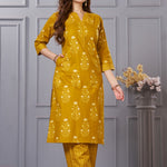 Side profile view of a model in the ochre yellow floral printed cotton kurta set showcasing the elegant side pockets and chevron trousers