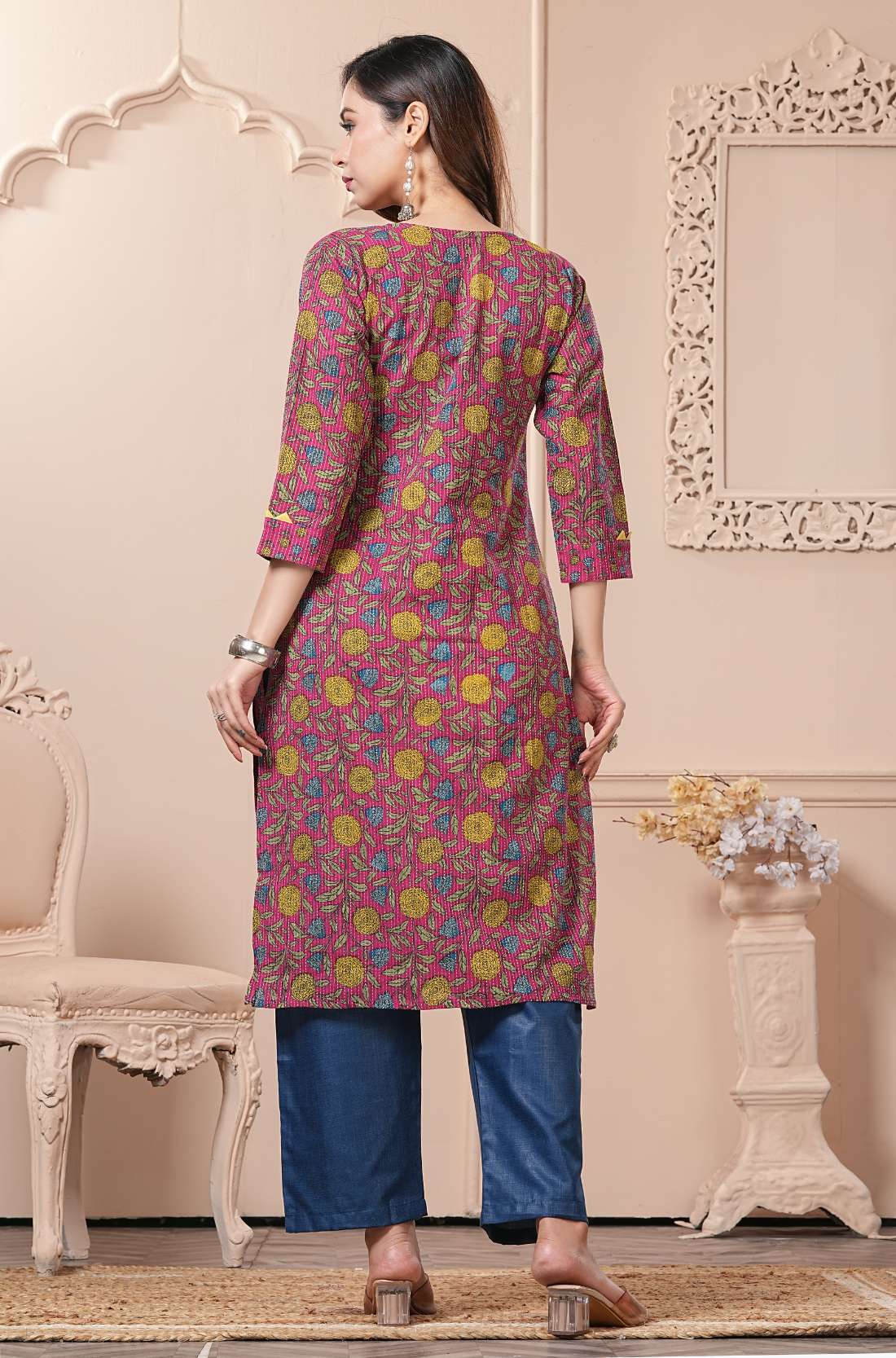 Rear view of the burgundy floral kurta - showing the all-over vine print - and the clean tailoring of the navy blue straight-cut trousers.
