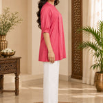 Full-length side profile view of a model showcasing the fit and puff sleeves of the dark peach rayon pleated top.