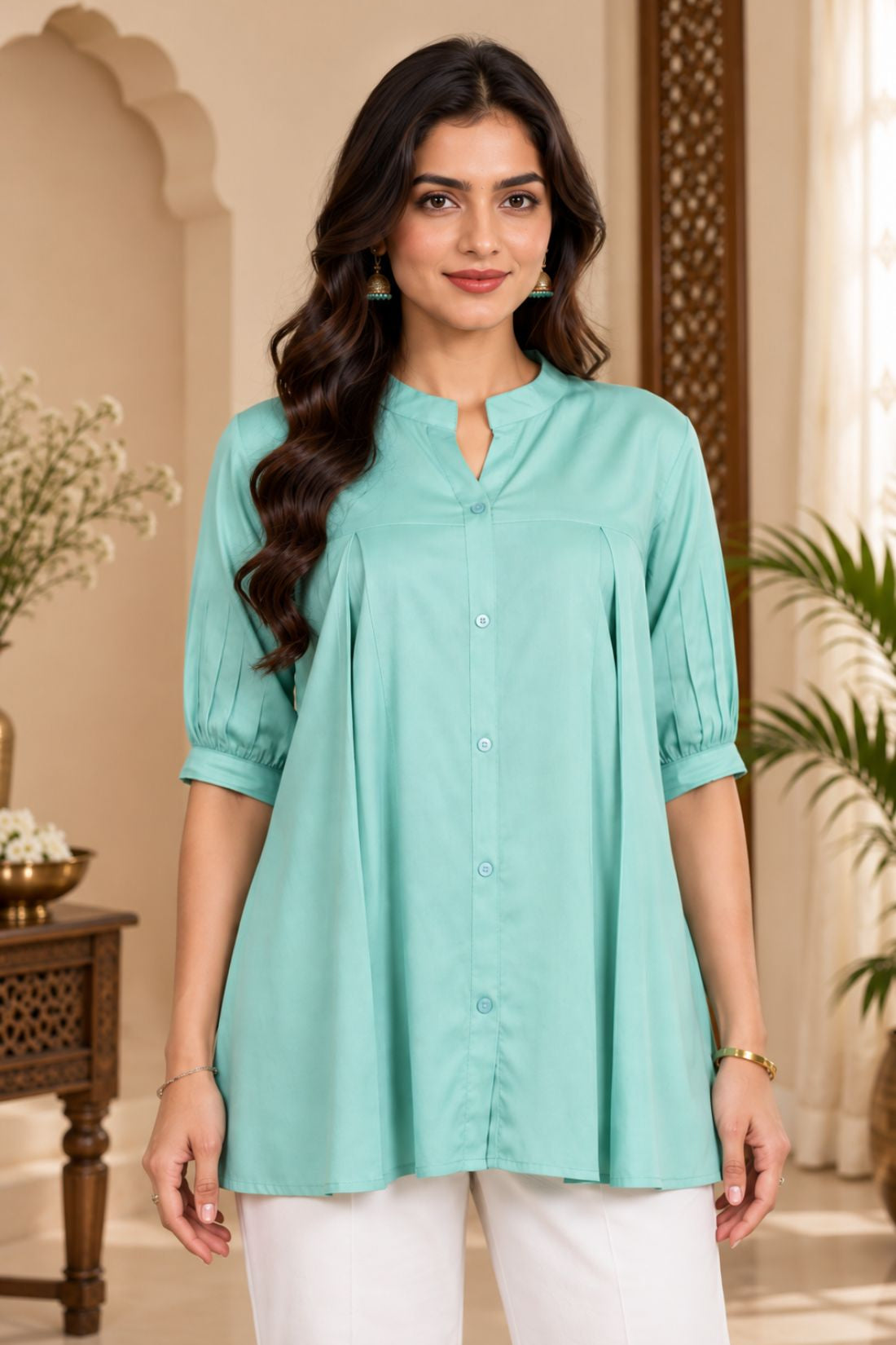 Close-up shot showing the collar, front button placket, and pleated details of the light sea green rayon top.