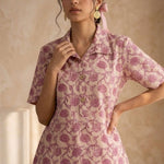 Front close-up of a women's blush pink floral block print cotton shirt featuring wooden buttons and collared neckline.