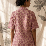 Back profile of a women's blush pink hand block print cotton shirt with short sleeves and curved hem.