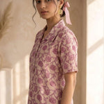 Side profile of a women's blush pink floral block print cotton shirt with relaxed fit and classic collar.
