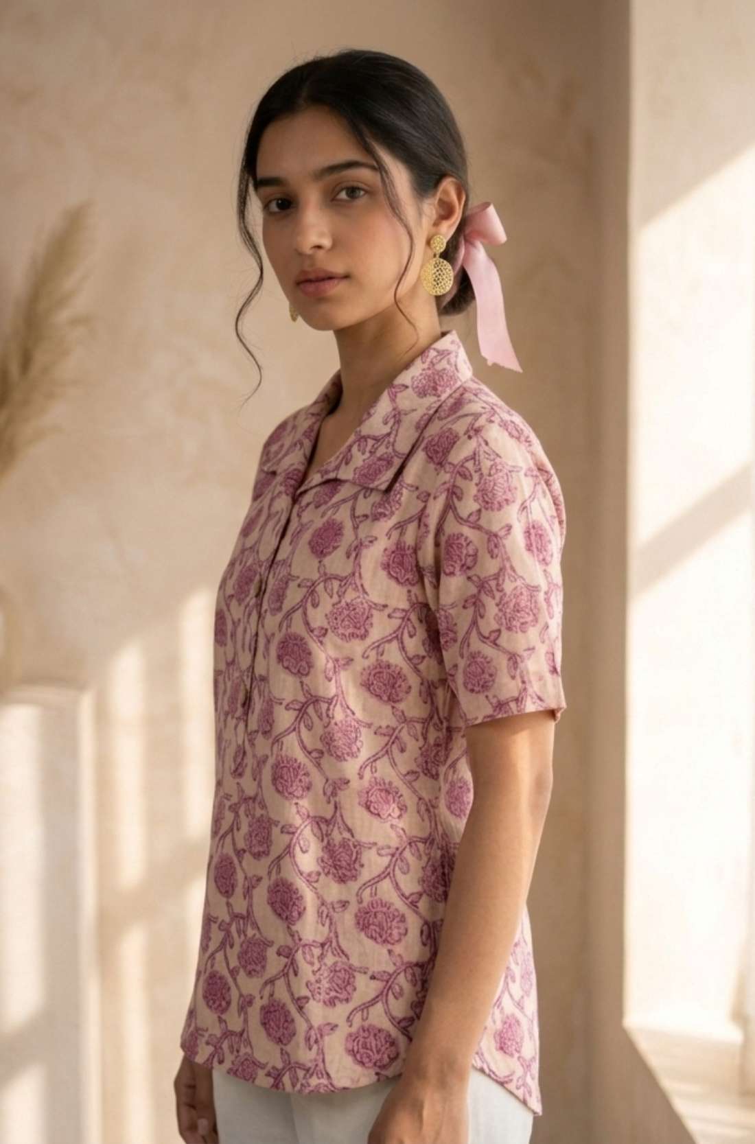 Side profile of a women's blush pink floral block print cotton shirt with relaxed fit and classic collar.