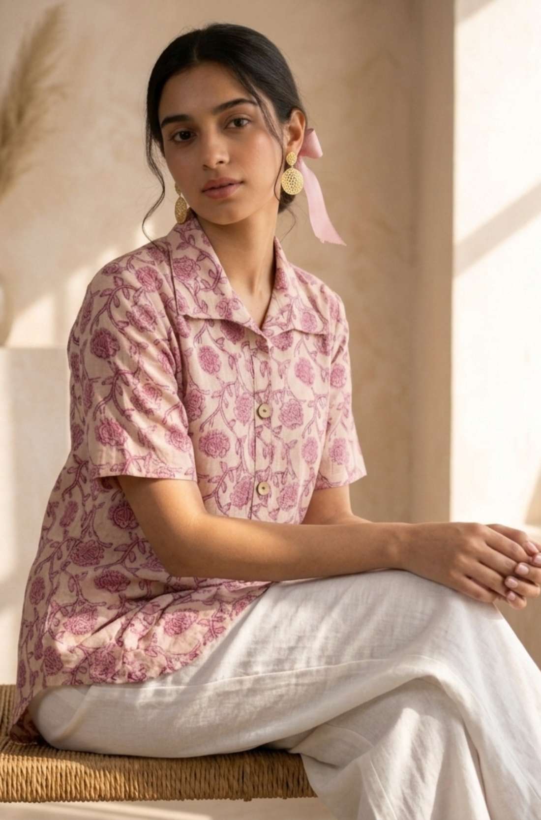 Front view of a women's blush pink floral hand block print cotton shirt with wooden buttons and short sleeves.