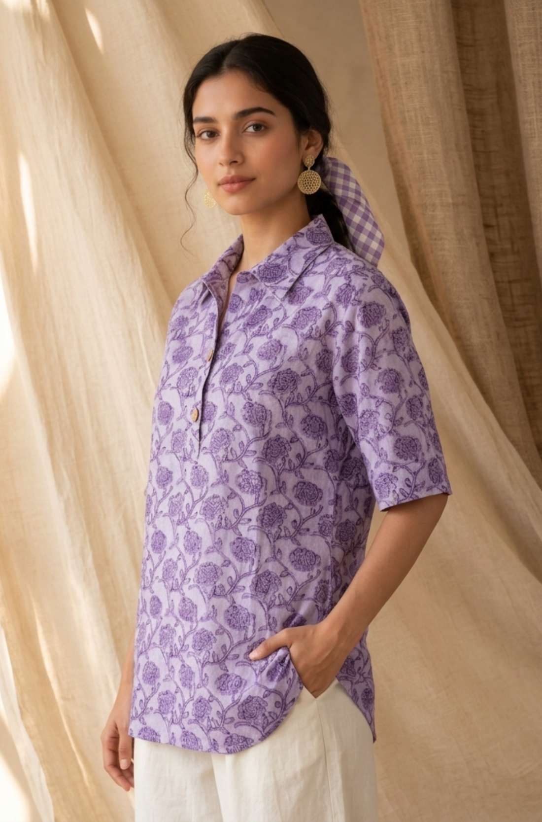 Side profile of a women's lavender floral block print cotton shirt paired with white trousers.