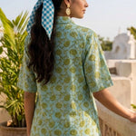 Back View
Back view of a women's mint green block print cotton shirt featuring short sleeves and curved hem.