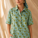 Front close-up of a women's mint green floral block print cotton shirt with wooden buttons and classic collar.