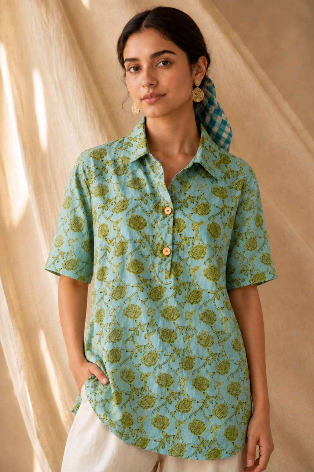 Front close-up of a women's mint green floral block print cotton shirt with wooden buttons and classic collar.