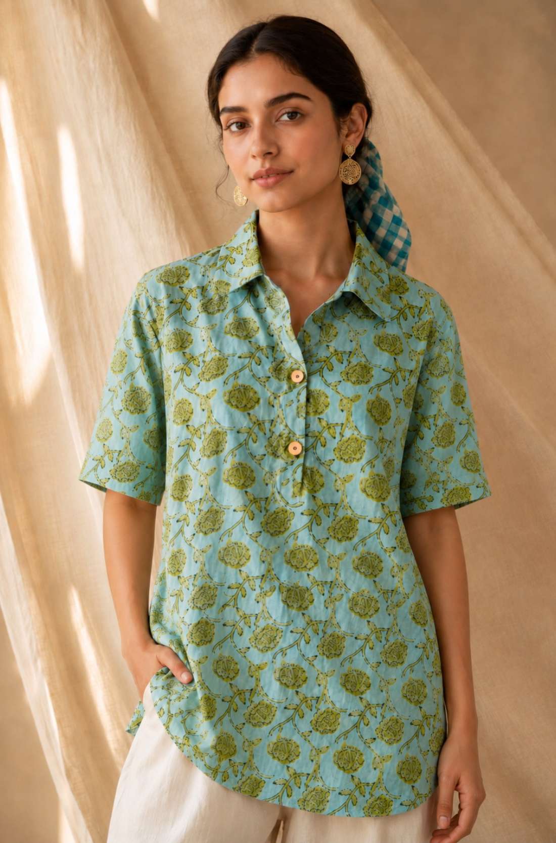 Front close-up of a women's mint green floral block print cotton shirt with wooden buttons and classic collar.