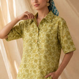 Front view of a women's yellow hand block print cotton shirt with wooden buttons and short sleeves.