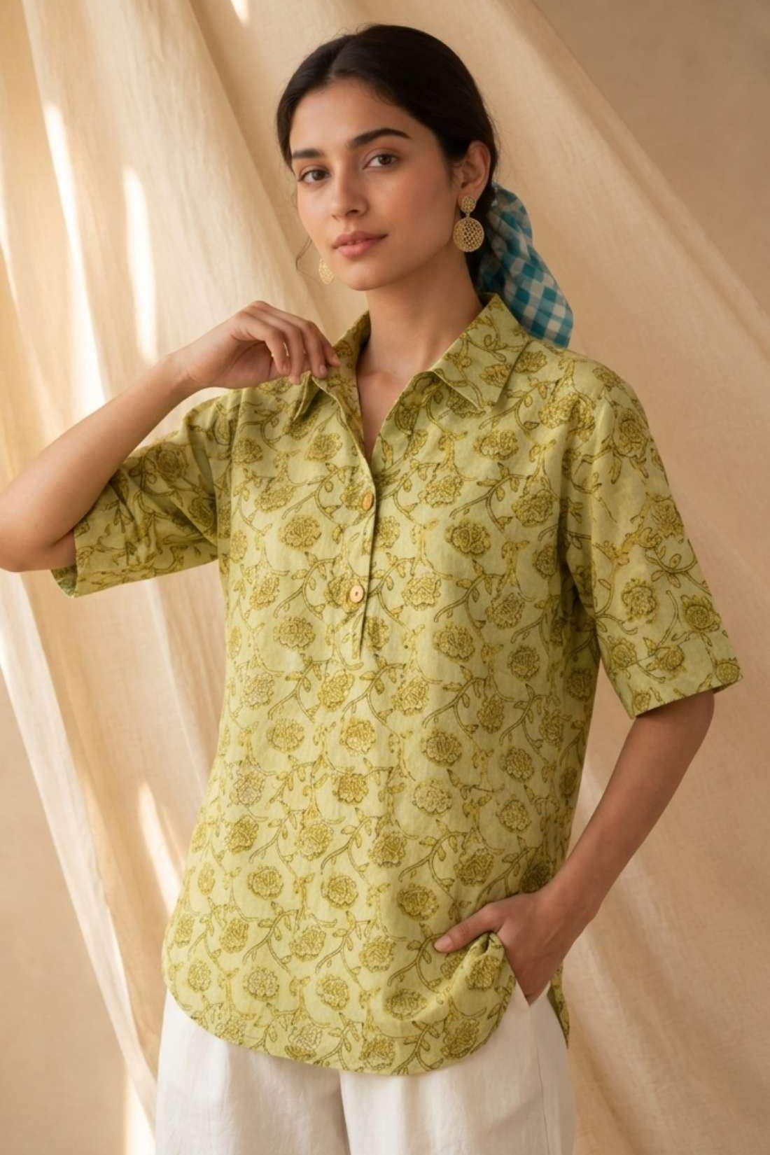 Front view of a women's yellow hand block print cotton shirt with wooden buttons and short sleeves.
