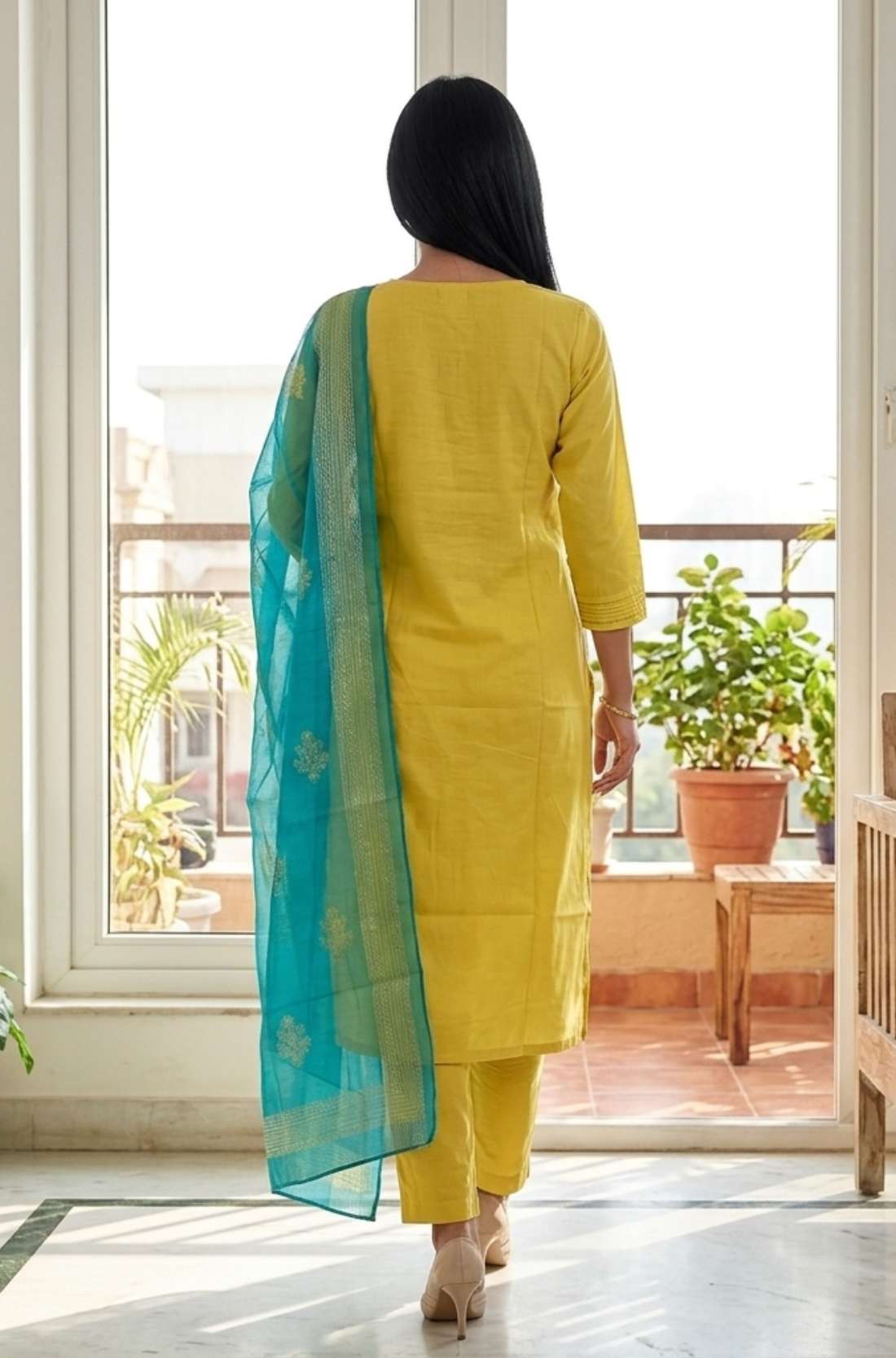 Back view of the straight fit yellow cotton embroidered kurta showing the fit and the printed dupatta drop