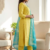 Side profile view of a model wearing a yellow cotton salwar suit showcasing the straight cut fit and matching patterned printed dupatta