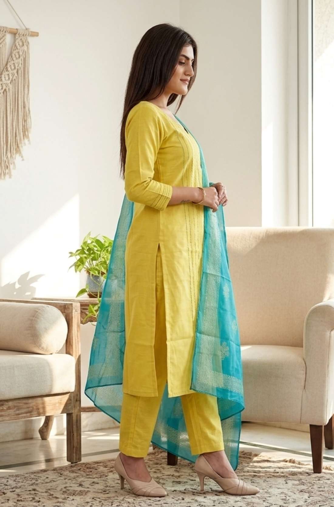 Side profile view of a model wearing a yellow cotton salwar suit showcasing the straight cut fit and matching patterned printed dupatta