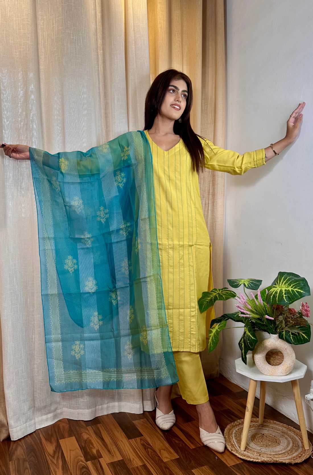 Yellow kurta set with dupatta spread wide in styling way.